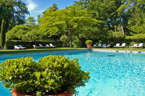 - une piscine avec des chaises et des plantes dans la cour dans l'établissement Château d'Arpaillargues - TERITORIA, à Arpaillargues-et-Aureillac