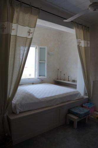 a bedroom with a large bed and a window at Almyra Kythera in Agia Pelagia Kythira