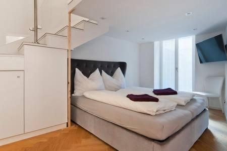 ウィーンにあるHomestay Sisiの白いベッドルーム(大型ヘッドボード付きのベッド1台付)