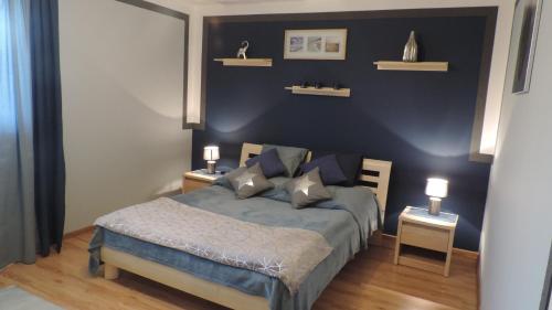 sypialnia z łóżkiem i dwoma stołami z lampkami w obiekcie Apartament Krystyna w mieście Tylicz