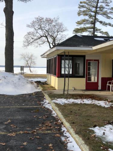 a house with a red door and snow on the ground at Sun N Snow Hotel in Cadillac