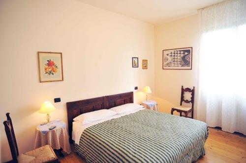 a bedroom with a bed and two tables and two lamps at Al Vajo in Lazise