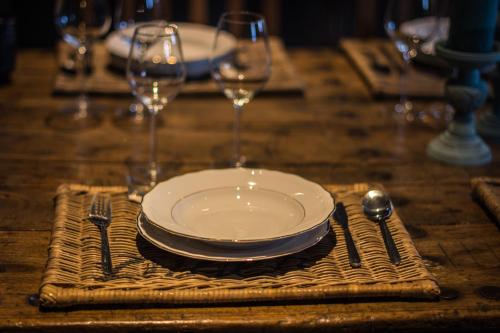 a table with a plate and two wine glasses at Hof ter Sysen in Loppem