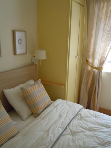 a bedroom with a white bed and a window at bord de mer in Sint-Idesbald