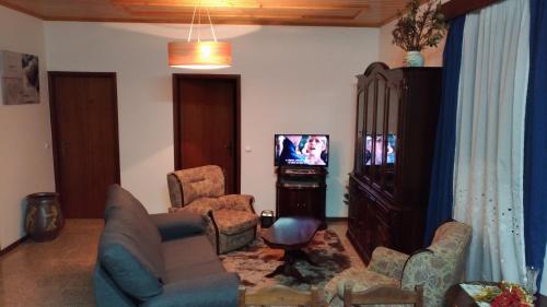 a living room with couches and a tv in it at Ape Esquerdo in São Vicente