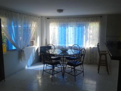 a dining room with a table and chairs and a window at Casa de Campo Palmarito in Tubará