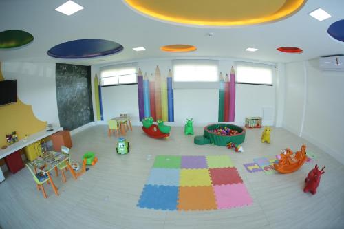 a room with a play area with toys and a rug at Apart Porto das Dunas in Aquiraz