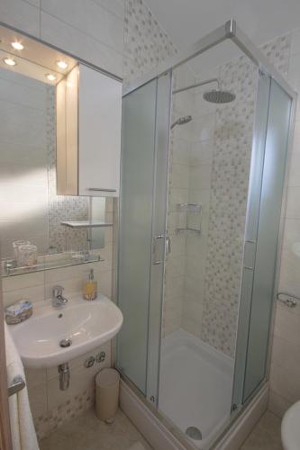 a bathroom with a shower and a sink at Apartmani Srdoč in Baška