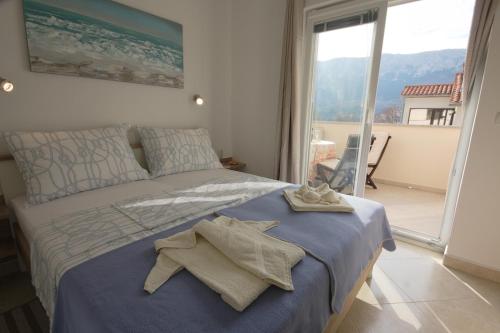 a bedroom with a bed with towels on it at Apartmani Srdoč in Baška