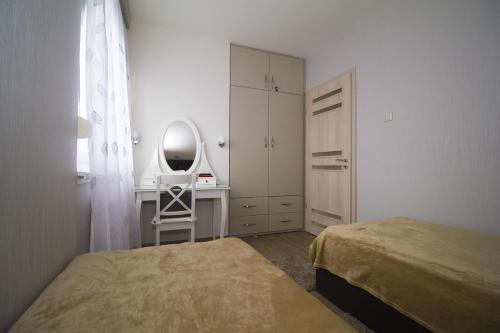 a bedroom with a bed and a dressing table and a mirror at Chez moi in Debrecen