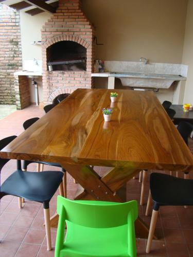 a wooden table with green chairs around it at Sur Backpackers in Santa Cruz de la Sierra