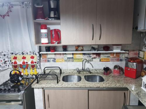 une cuisine avec un évier et une cuisinière dans l'établissement Apartamento no Centro de Canela, à Canela