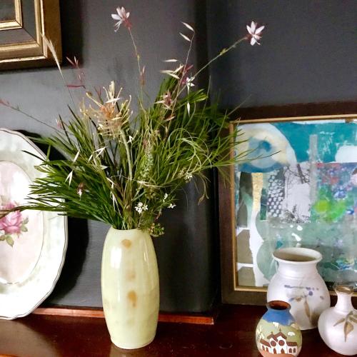 a white vase with flowers in it on a table at Vine Valley Inn in Cessnock