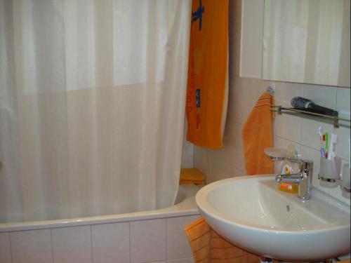 een badkamer met een wastafel, een douche en een bad bij Primel (385 Sw) Whg. Manuela in Tiefencastel