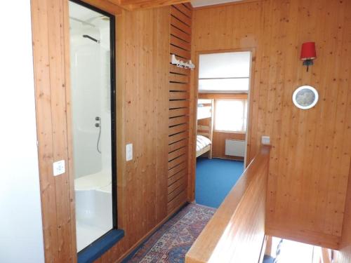 ein Badezimmer mit holzgetäfelten Wänden und einer Badewanne in der Unterkunft Las Bargias 8 (472 Me) in Lenzerheide