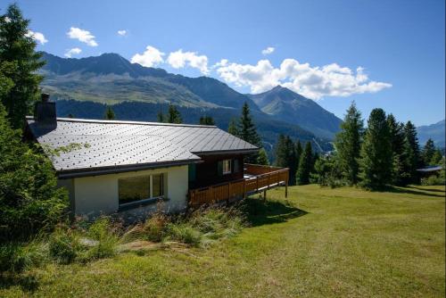 a house in a field with mountains in the background at Oreas (724 Du) in Valbella