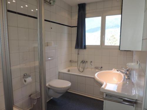 a bathroom with a toilet and a sink and a tub at Montalin (451 Ti) 1. Stock in Valbella