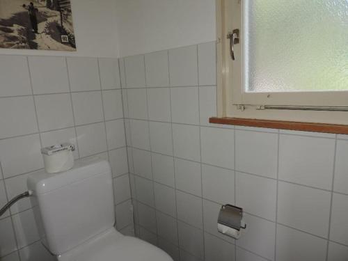 a white bathroom with a toilet and a window at Montalin (451 Ti) 1. Stock in Valbella