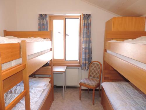 Ce dortoir comprend des lits superposés, une chaise et une fenêtre. dans l'établissement Barhetta (389 Ma), à Lenz