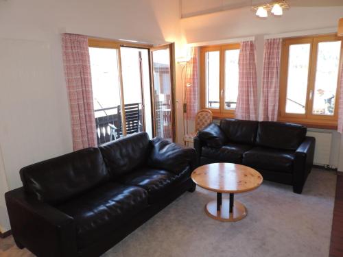 a living room with a black leather couch and a table at Barhetta (389 Ma) in Lenz