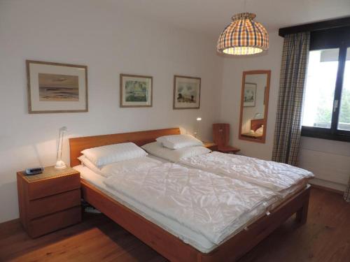 a bedroom with a large bed and a lamp at Bella Val (206 Se) in Lenzerheide
