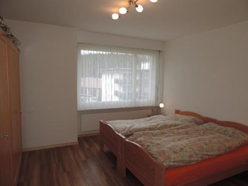 a bedroom with a bed and a window at Astoria (287 Du) in Lenzerheide