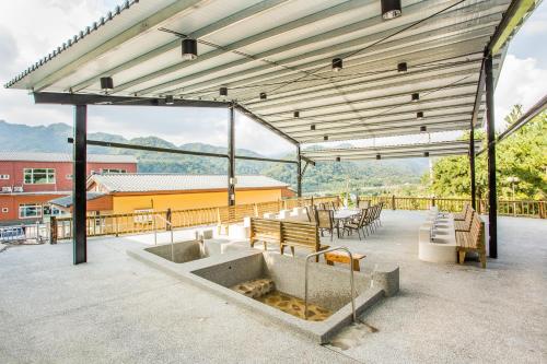 a pavilion with tables and benches on a patio at Bai Shengcun Homestay in Guoxing