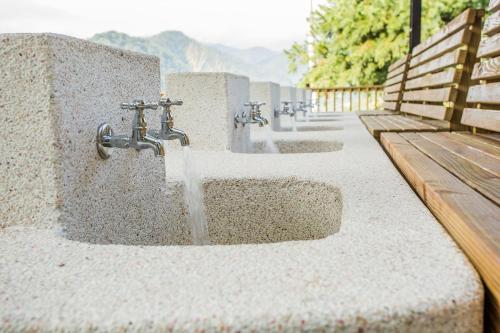 a row of water fountains in a park next to a bench at Bai Shengcun Homestay in Guoxing