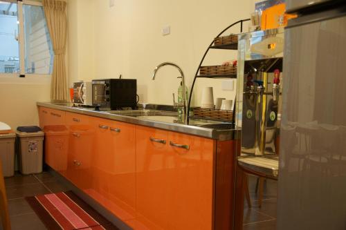 a kitchen with orange cabinets and a sink at Trip Village-Hulk's Homestay in Taitung City
