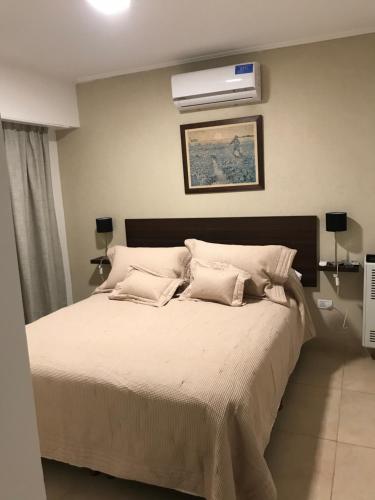 een slaapkamer met een bed met airconditioning aan de muur bij Don Ramon Departamentos Premium in Tandil
