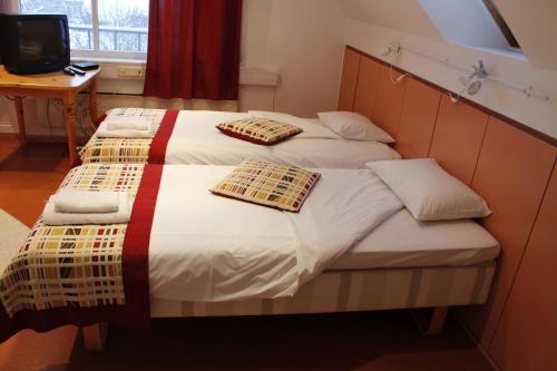 a bedroom with a bed with two pillows on it at Arno Apartments in Kuressaare