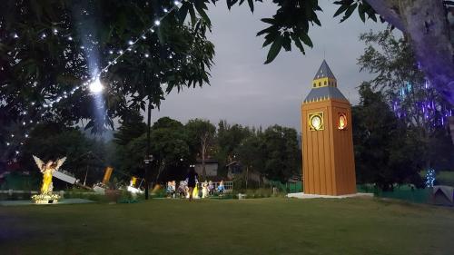 a large clock tower in a park at night at Titanic Park in Ratchaburi