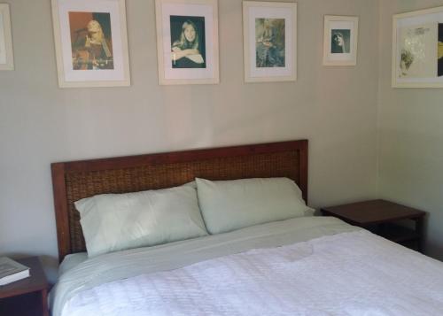 a bed in a bedroom with pictures on the wall at High On Penguin in Penguin
