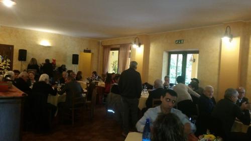 a group of people sitting at tables in a room at B & B OASI in Rosciano