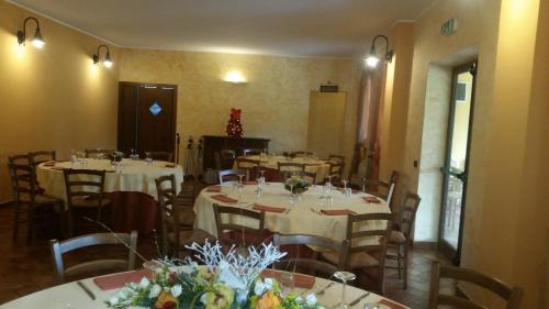 a dining room with tables and chairs with white linens at B & B OASI in Rosciano