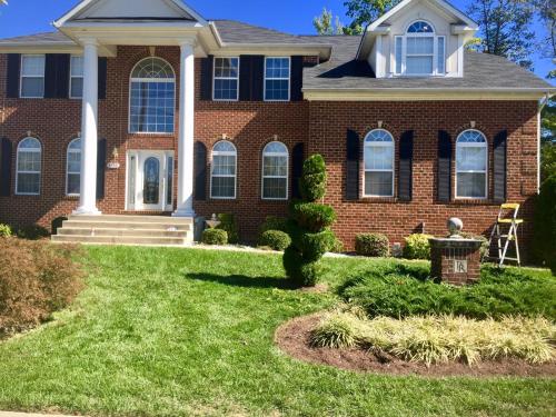 a brick house with a grass yard at Premier National Harbor House in Fort Washington