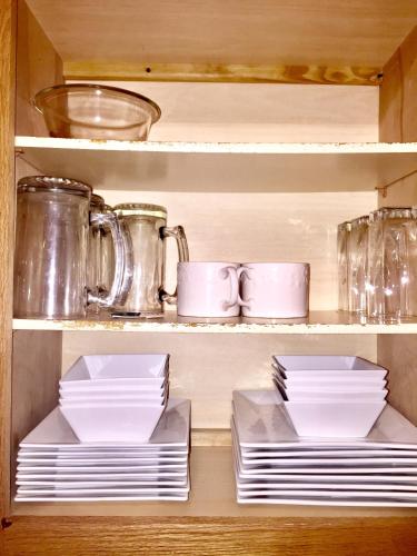 a cabinet filled with plates and cups and dishes at Premier National Harbor House in Fort Washington