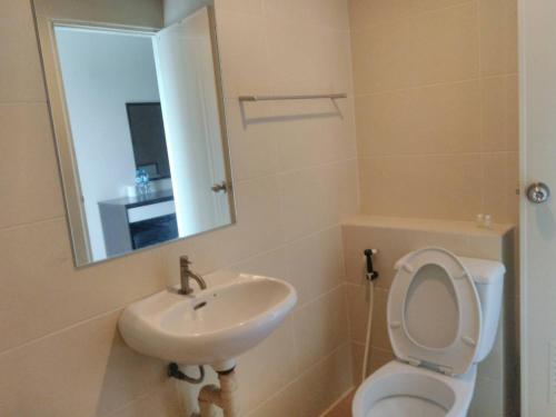 a bathroom with a sink and a toilet and a mirror at Crystal Place in Nonthaburi