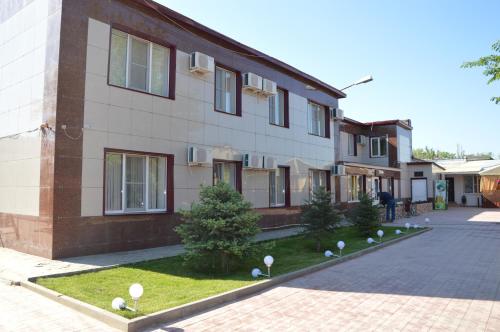 a brick building with a courtyard in front of it at Hotel Almaz in Akhtubinsk