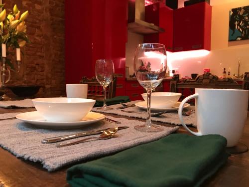 a table with two wine glasses and plates on it at The Lastage Inn - Bed & Breakfast in Amsterdam