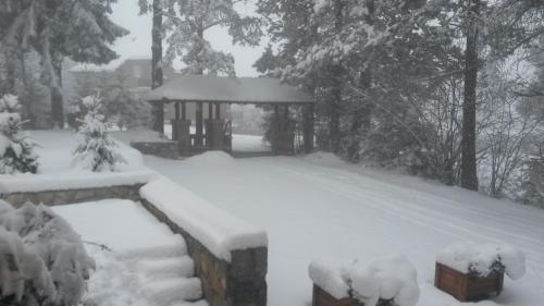 a gazebo covered in snow in a yard at Apartment Joksimovic in Zlatibor