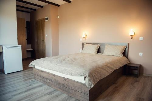 a bedroom with a large bed with two pillows at Vila Lidia in Tsigov Chark
