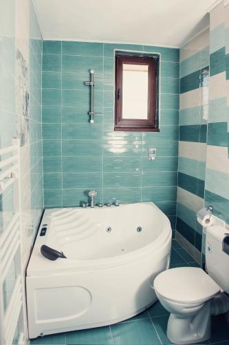 a bathroom with a white tub and a toilet at Vila Lidia in Tsigov Chark