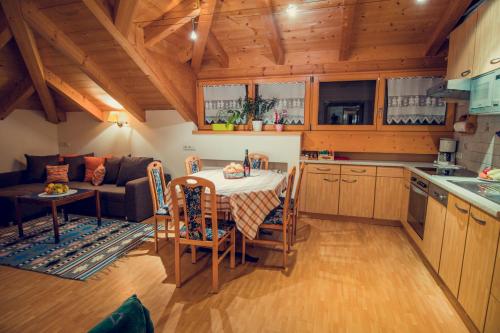 a kitchen and living room with a table and a couch at Appartements Tlusel in Ortisei