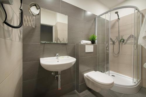 a bathroom with a sink and a toilet and a shower at Hotel Energie in Prague