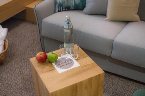 a table with a bottle and two apples on it at Hotel Der Waldhof in Zell am See