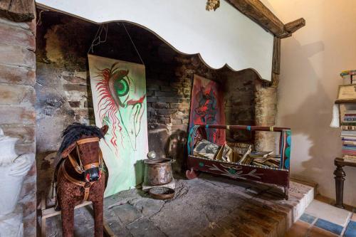 a room with a fireplace with paintings on the wall at Agriturismo Il Poggio degli Scoiattoli in Perugia