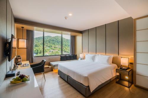 Postel nebo postele na pokoji v ubytování Arize Hotel Sri Racha