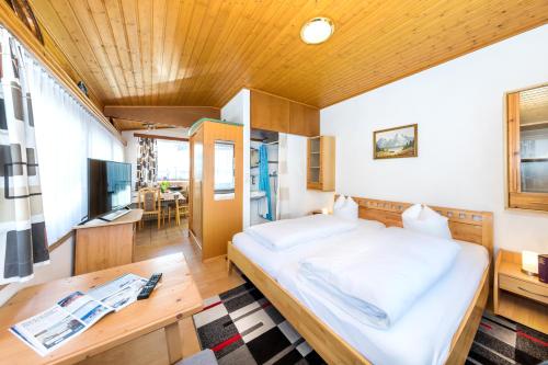 ein Schlafzimmer mit einem großen Bett und einem Tisch in der Unterkunft Appartements Haus Sonnenschein in Zell am See