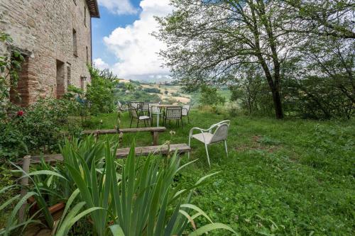 a group of chairs and tables in a garden at Agriturismo Il Poggio degli Scoiattoli in Perugia
